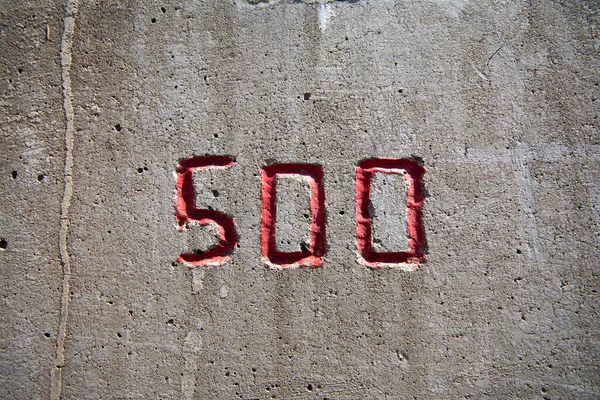 Kırmızıyla beton bir duvara oyulmuş 500 numara.