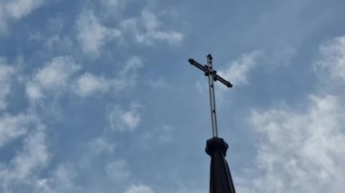 Haç, Katolik tapınağının kubbesine, kilisenin üzerine, yüzen beyaz bulutların arka planına yerleştirilir. Konu din..