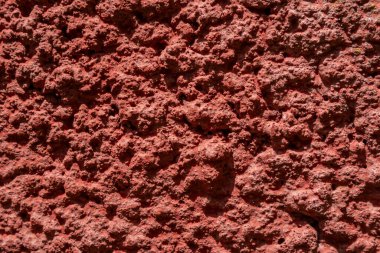 Duvar kırmızı kaba alçıyla kaplı. Doku, arka plan. Arkaplan