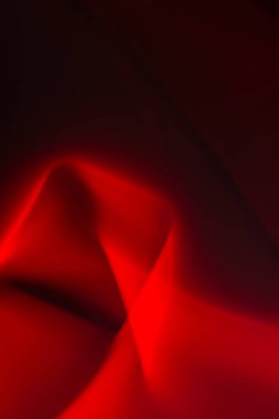 Siyah zemin üzerinde pürüzsüz çizgileri olan soyut kırmızı duman ve ışık. Uzayı kopyala Tasarım ögesi.