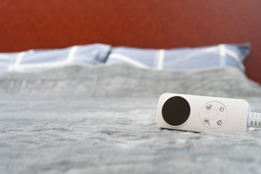 Yatay kompozisyonda yatağın üzerinde kontrollü elektrikli battaniye.