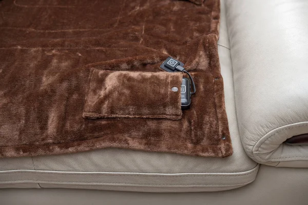 ソファの上の電源としてポータブル充電器付きの電気毛布 — ストック写真