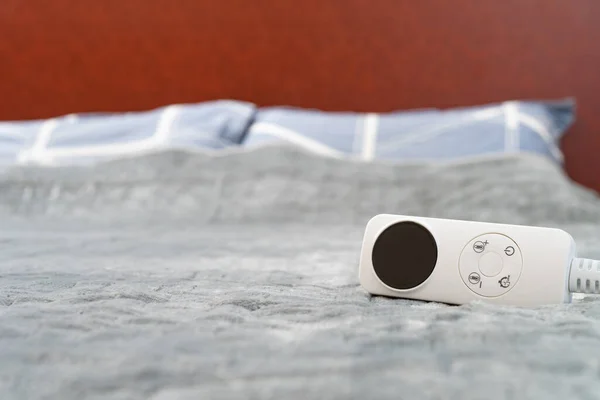 水平構成のベッドの上にコントローラー付きの電気毛布 — ストック写真