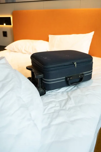 旅馆房间床上的蓝色行李垂直构图 — 图库照片