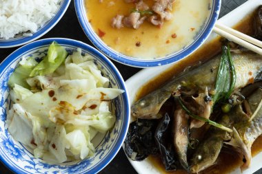 İki Pelteobagrus fulvidraco ve haşlanmış yumurta, sebze ve bir kase pirinç yatay kompozisyonu.