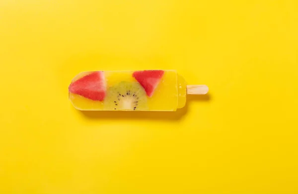 top view fresh yellow peach flavor with kiwi and strawberry slices popsicle on yellow background