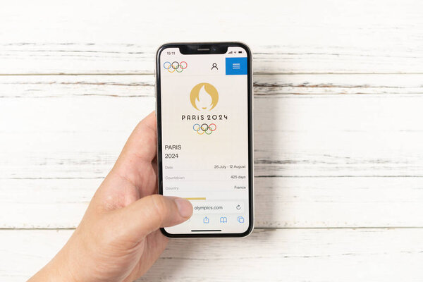 ZHONGSHAN China-May 29,2023:man looking on the official website of Paris Olympic Games 2024 on mobile horizontal composition.