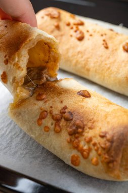 Fırınlanmış peynirli biftek rulosuyla açılı el.