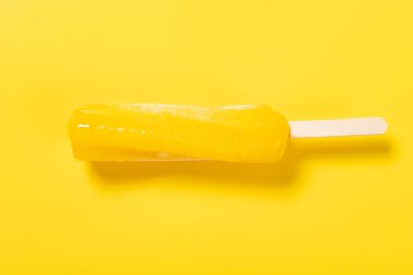 Üst görünüm bükülmüş ananas aromalı dondurma sarı arka planda erimeye başlar