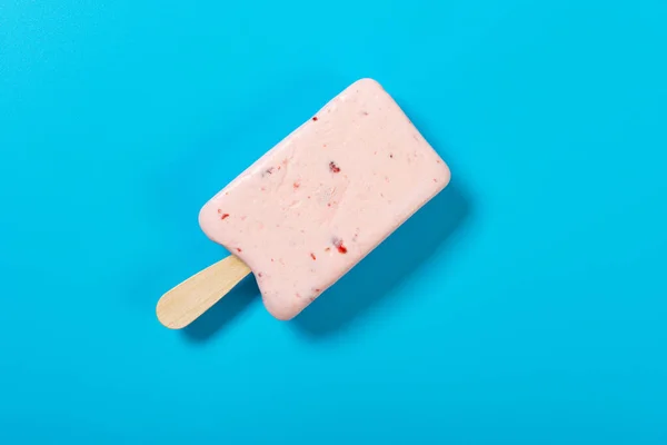 Eis Stiel Mit Erdbeergeschmack Beginnt Auf Blauem Hintergrund Schmelzen — Stockfoto