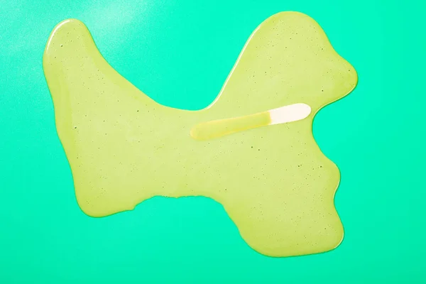 top view melted matcha and milk flavor popsicle on green background