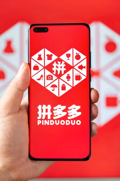 Zongshan China June 262023 垂直組成でPinduoduoロゴ付き携帯電話を持つ男 — ストック写真