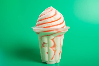 cup of strawberry flavor ice cream on green background