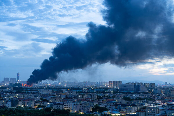 a factory catched a fire with lots dark smoke in sunset time horizontal composition