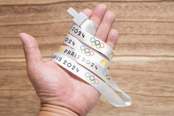 ZHONGSHAN China-August 18,2023:mans hand wrapped with a strap printed with Paris Olympic Games 2024 logo.