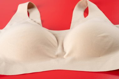 Açı görünümü kırmızı arka plandaki kadınlar için bej sutyen