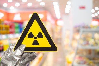 Süpermarket raflarının önünde nükleer radyasyon uyarısı işareti