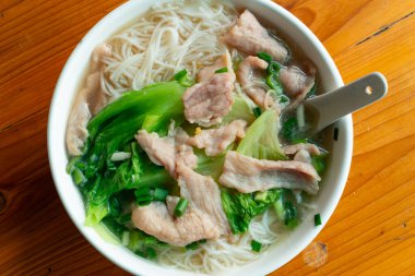 Yatay kompozisyonda domuz etli pirinç eriştesi ve lahana.