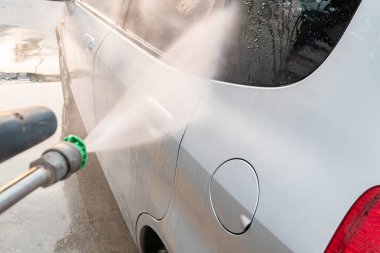 Bir arabayı yatay kompozisyonda suyla yıkamak