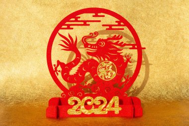 Çin Yeni Yılı Ejder 2024 maskot kağıdı altın arka planda. Çince 'nin yatay İngilizce çevirisi şans ve logo yok. Ticari marka yok.