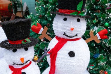 Yatay bileşimde köknar ağacının yanında iki kardan adam.