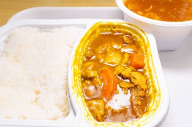 Köri soslu tavuk, pilav ve bir kase yengeç yumurtası aromalı çorba.