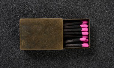 Üst görünüm bakır kibrit kutusu ile pembe renk kibrit çöpleri yatay bileşim