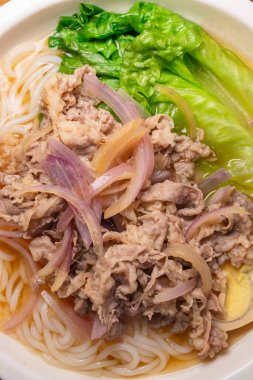 Dikey kompozisyonda yağlı etli erişte çorbası.