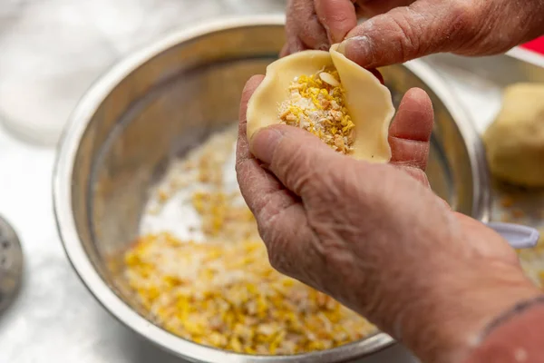 elder lady making Guangdong-style crispy pastry dumplings for Chinese New Year