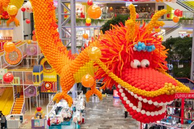 ZHONGSHAN Çin - 30 Ocak 2024: Yatay kompozisyondaki bir alışveriş merkezinde balonlardan yapılmış dev boyutta bir ejderha.