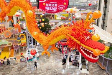 ZHONGSHAN Çin - 30 Ocak 2024: Yatay kompozisyondaki bir alışveriş merkezinde balonlardan yapılmış dev boyutta bir ejderha.