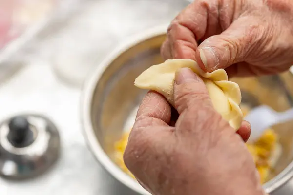 elder lady making Guangdong-style crispy pastry dumplings for Chinese New Year