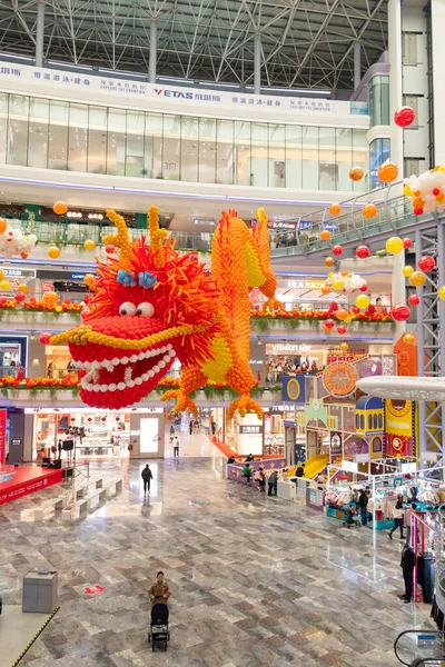 ZHONGSHAN Çin - 30 Ocak 2024: Dikey kompozisyondaki bir alışveriş merkezinde balonlardan yapılmış dev boyutta bir ejderha.