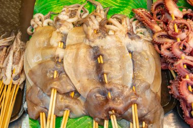 Yatay bileşimde ham mürekkep balığı şişleri