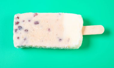 Yeşil arka planda kırmızı fasulyeli milkshake aromalı buzlu dondurma.