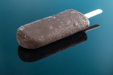 chocolate outer popsicle on blue background with reflection clipart