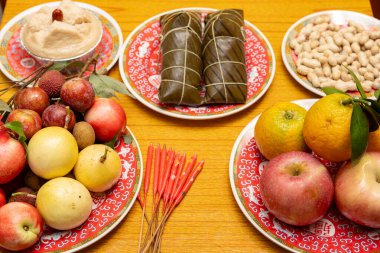 Zongzi ve çeşitli meyvelerle dolu bir masa. Ejderha Teknesi Festivali için geleneksel adaklar olarak bir pasta ve fıstık.