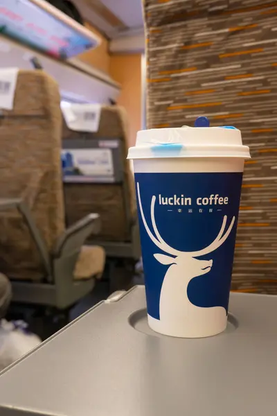 stock image GUILIN GUANGXI China-July 14 2024:cup of luckin coffees on a table in a High-Speed train at vertical composition.