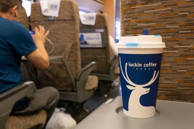 GUILIN GUANGXI Çin-14 Temmuz 2024: Yüksek hızlı bir trende masanın üzerinde bir fincan uğurlu kahve.