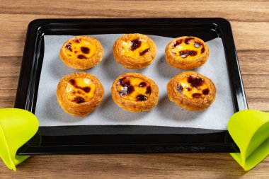 Yatay kompozisyonda fırın tepsisinde taze Portekiz yumurtaları.