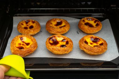 Yatay kompozisyonda fırın tepsisinde taze Portekiz yumurtaları.