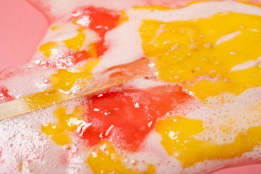 Açı görünümü beyaz şeftali aromalı lolipop pembenin üzerinde erimiş.