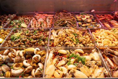 Kalamar ve deniz salyangozu ve yengeç ve karides ve diğer deniz ürünleri bir sokak tezgahında.