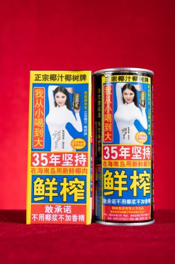 ZHONGSHAN China-July 1,2023:box and can of YeShu coconut milk on red at vertical composition. clipart