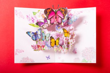 Üstünde bir sürü güzel kelebek olan pembe 3D hediye kartı.