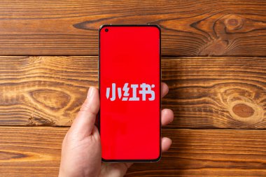 ZHONGSHAN Çin-28 Ocak 2025: Üzerinde Rednote logosu olan bir cep telefonu taşıyan adam yatay kompozisyonda.