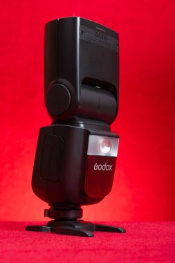 ZHONGSHAN GUANGDONG Çin-16 Aralık 2024: Vejetaryen kompozisyonunda kırmızı üzerine Godox V860III N fener.