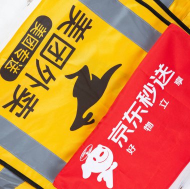 Zhongshan, Çin-25 Nisan 2025: JD ve MeiTuan dağıtım personeli üniformaları yatay kompozisyonda.