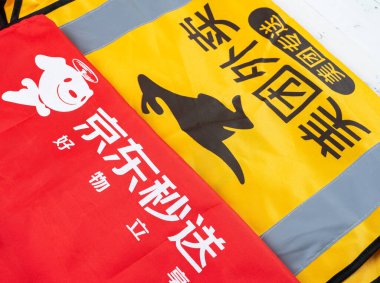 Zhongshan, Çin-25 Nisan 2025: açı görünümü JD ve MeiTuan dağıtım personeli üniformaları yatay kompozisyonda.