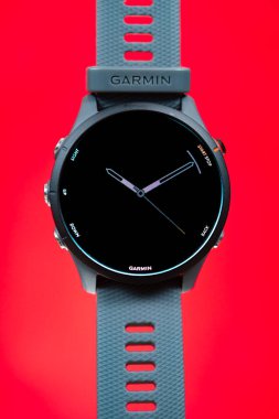 ZhongShan Çin-20 Mayıs 2025: Garmin Forerunner 255 dikey kompozisyonda kırmızı üzerine spor saati.